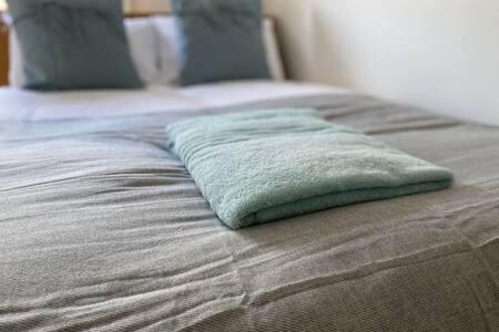 almohada verde sobre la cama en Tudor House Gloucester by StayStaycations en Gloucester