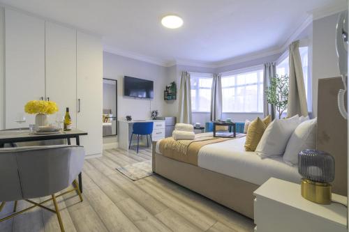 a bedroom with a bed and a desk and a kitchen at 12 Elmwood in Harrow