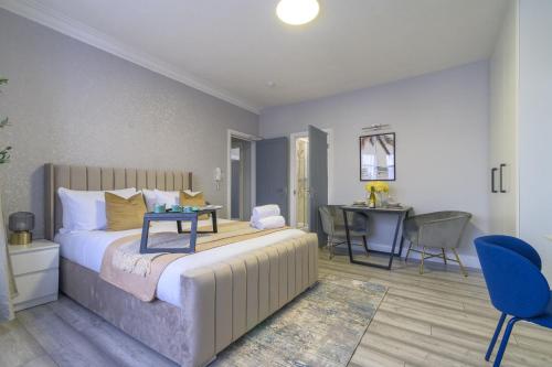a bedroom with a bed and a table and a desk at 12 Elmwood in Harrow