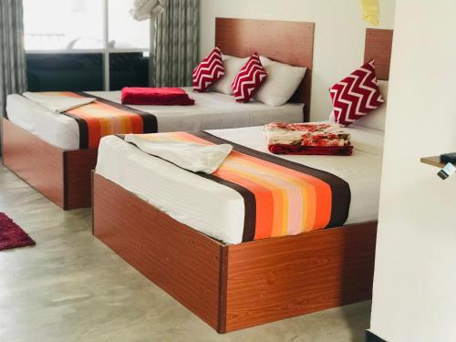 a bedroom with two beds with colorful blankets at Ella Jayamali Holiday Pavilion in Ella