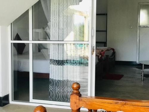 a room with a sliding glass door to a bedroom at Ella Jayamali Holiday Pavilion in Ella