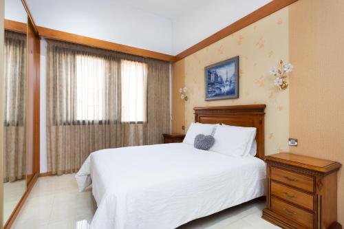 a bedroom with a large white bed and a window at Home2Book Charming House Private Pool & Terrace in Santa Cruz de Tenerife