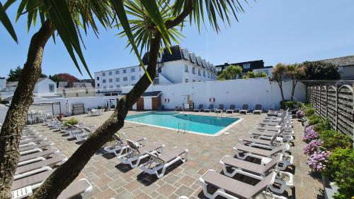 una piscina con tumbonas y un complejo en Norfolk Hotel, en Saint Helier Jersey