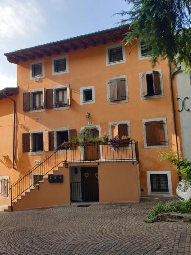 ゴリツィアにあるIntero Appartamento "ALLE MURA DEL CASTELLO Stefano e Paola Marchesini"のバルコニーと階段が備わるオレンジ色の建物です。