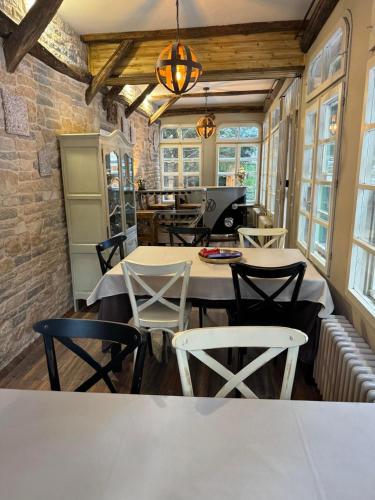 a dining room with tables and chairs and windows at Villa Adis with Hot Pool & Jacuzzi by BookVillaBG in Borovets
