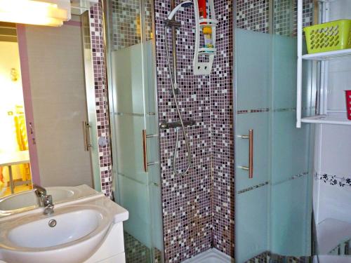 une salle de bain avec un lavabo et une douche en verre dans l'établissement Charmante Maisonnette avec Piscine près de la Plage, Parking, et Animaux Acceptés - FR-1-387-103, à Marseillan