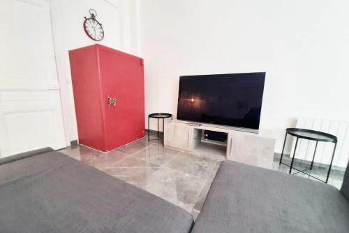 - une chambre avec une armoire rouge et une télévision à écran plat dans l'établissement Sweet Apartment in Paris Montmartre, à Paris