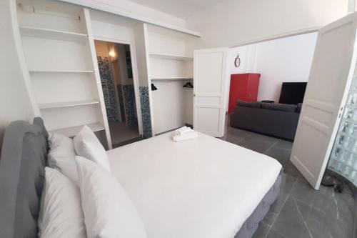 une chambre avec un lit blanc et un canapé dans l'établissement Sweet Apartment in Paris Montmartre, à Paris
