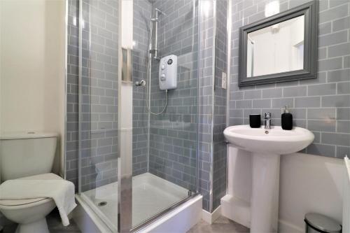 a bathroom with a shower and a sink and a toilet at Signature - Great Western View in Whiteinch