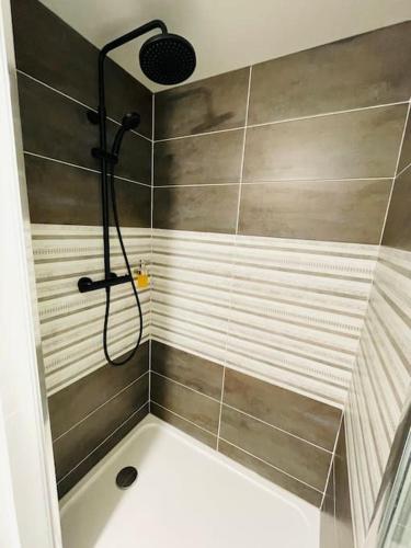 une douche avec pommeau de douche dans une salle de bain dans l'établissement Studio 1 agréable et spacieux à la gare de Lorient, à Lorient