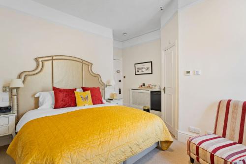 a bedroom with a large yellow bed with red pillows at Kingston House in Torquay