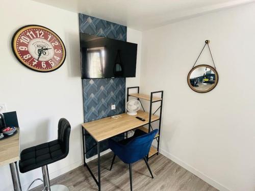 een bureau en stoelen in een kamer met een muur bij Studio 1 agréable et spacieux à la gare de Lorient in Lorient