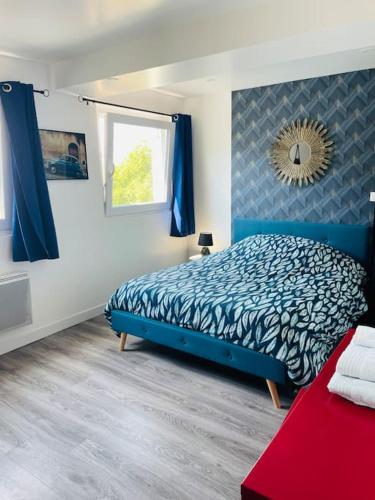 une chambre avec un lit bleu et un miroir dans l'établissement Studio 1 agréable et spacieux à la gare de Lorient, à Lorient