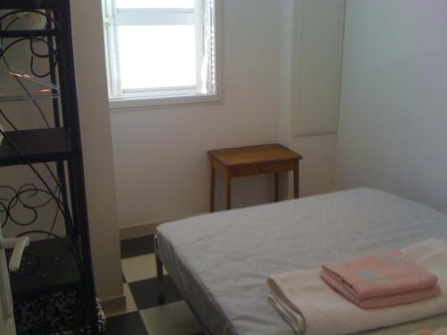 um pequeno quarto com uma cama e uma janela em maison T3 500m de la plage em Poggio-Mezzana