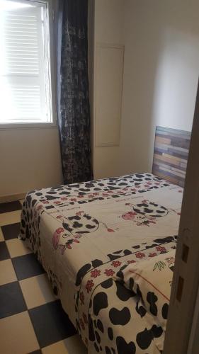 - une chambre avec un lit et une couverture de vache dans l'établissement maison T3 500m de la plage, à Poggio-Mezzana