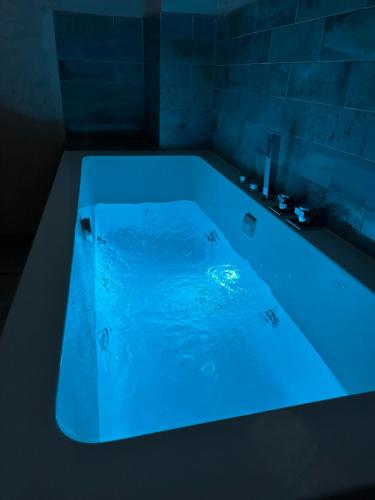 uma banheira com iluminação azul na casa de banho em Cherry JACUZZI Apartment em Ronda