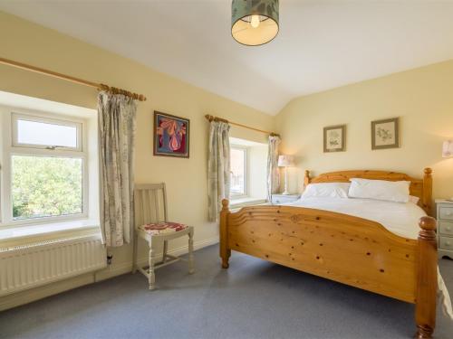 a bedroom with a wooden bed and a window at 3 Bed in Thornham KT111 in Thornham