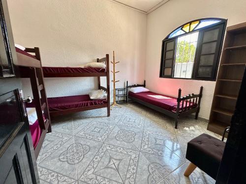 Zimmer mit 2 Etagenbetten und einem Fenster in der Unterkunft Casa aconchegante em Peruíbe in Peruíbe