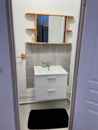 une salle de bain avec un lavabo et un miroir dans l'établissement Le Blaisois, à Blois