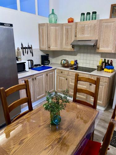 une cuisine avec une table en bois et un vase. dans l'établissement Le Blaisois, à Blois