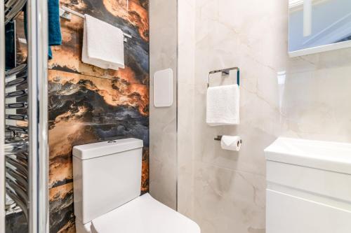 a bathroom with a toilet and a sink at 12 Elmwood in Harrow