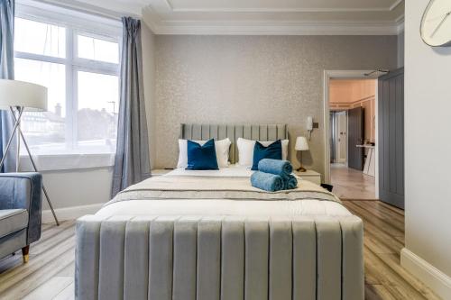 a bedroom with a large bed with blue pillows at 12 Elmwood in Harrow