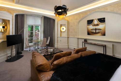 a living room with a brown couch and a fireplace at Talbooth House & Spa in Dedham