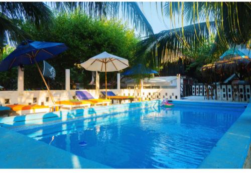 una gran piscina con sillas y sombrillas en Eco hotel summer beach, en Cartagena de Indias