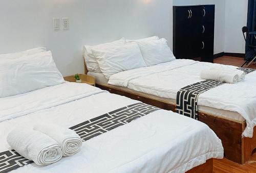 duas camas num quarto com lençóis brancos e toalhas em Stay Inn Station 1 Boracay by RedDoorz em Boracay