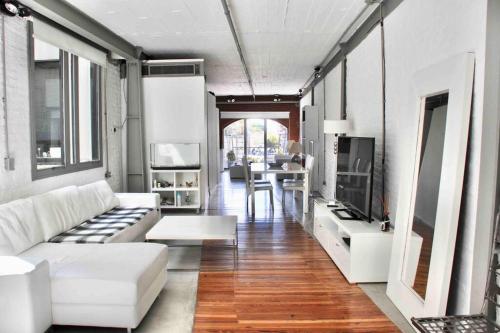 sala de estar con sofá blanco y TV en Hermoso departamento en Puerto Madero con vista al río en Buenos Aires