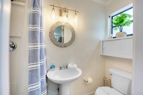 a bathroom with a sink and a mirror and a toilet at Overlooking Saltwater Lagoon Free Golf Cart-Kayaks in Key Largo