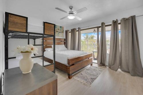 a bedroom with a bed and a vase with flowers on a table at Overlooking Saltwater Lagoon Free Golf Cart-Kayaks in Key Largo