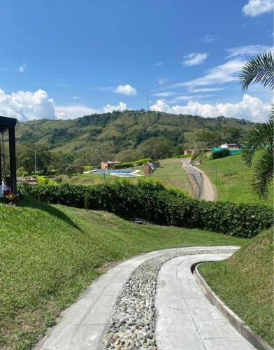 une route de gravier dans un champ avec une montagne dans l'établissement Casa Campestre Sector Kilometro 41, à Manizales