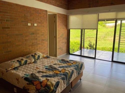 - une chambre avec un lit et un mur en briques dans l'établissement Casa Campestre Sector Kilometro 41, à Manizales