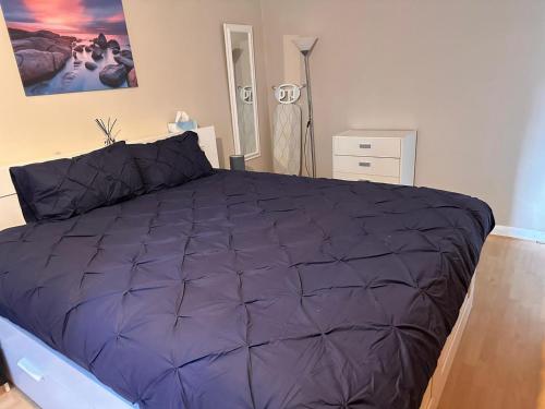 a bedroom with a large purple bed in it at Letzi - Modern 2 Bedroom Apartment Near Heathrow in Hillingdon