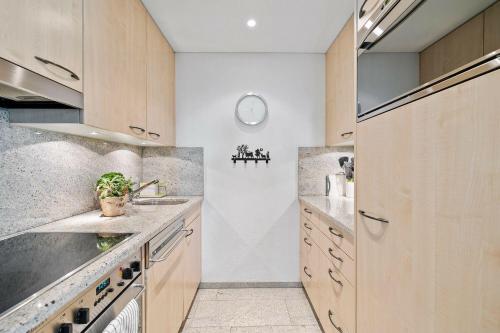 a kitchen with wooden cabinets and stainless steel appliances at Seestrasse 3, Whg 104 in Lenzerheide