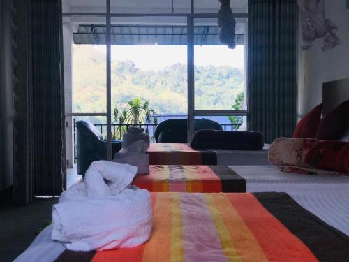 a bedroom with a bed and a large window at Ella Jayamali Holiday Pavilion in Ella