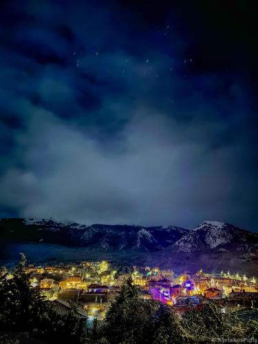 a view of a city at night with lights at G & M Stone House in Palaios Agios Athanasios