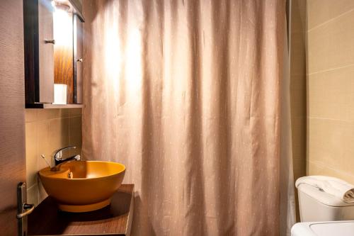 a bathroom with a sink and a shower curtain at G & M Stone House in Palaios Agios Athanasios