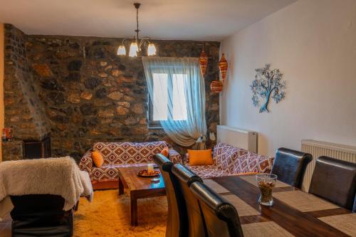 een woonkamer met een tafel en een bank bij G & M Stone House in Palaios Agios Athanasios