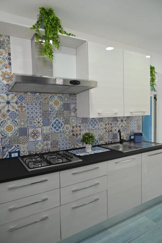a kitchen with white cabinets and a stove at Vesuvius Dream in Boscotrecase