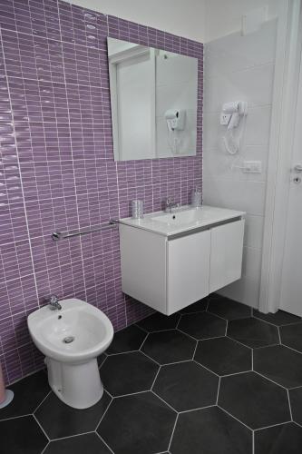 a bathroom with a sink and a toilet and a mirror at Vesuvius Dream in Boscotrecase