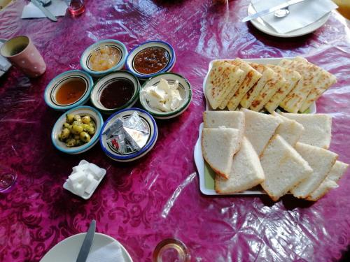 een tafel met een bord brood en diverse dips bij Gite chez Ali Agouti Maison Berbère in Idoukaln
