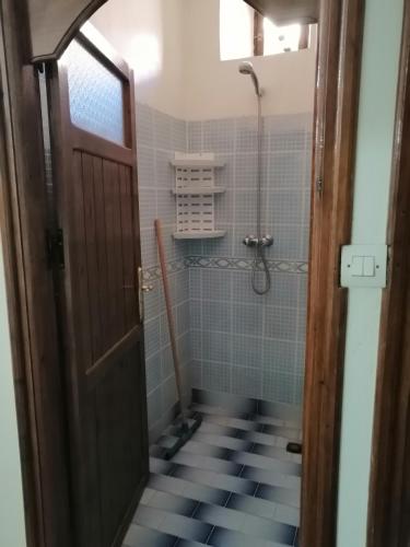 a bathroom with a shower and a door at Gite chez Ali Agouti Maison Berbère in Agouti