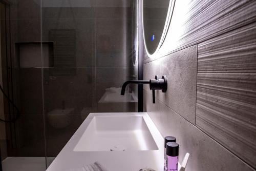 un bagno con un lavandino bianco e una doccia di Alipa Suite with Jacuzzi a Monopoli