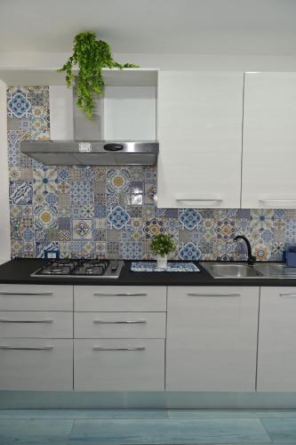 a kitchen with white cabinets and a sink at Vesuvius Dream in Boscotrecase