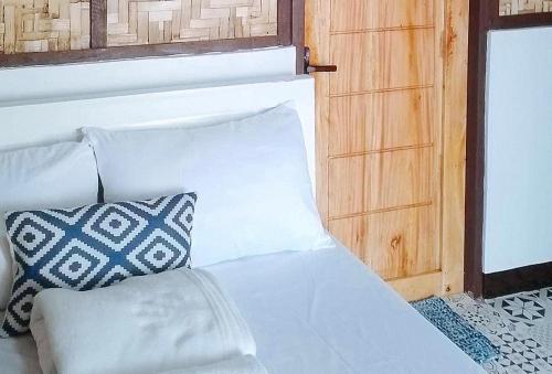 a white couch with two pillows next to a window at Langub Beach Resort Sipalay by RedDoorz in Sipalay