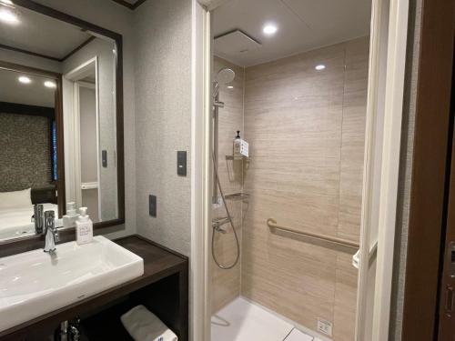 a bathroom with a shower and a sink at Kikunoya in Miyajima