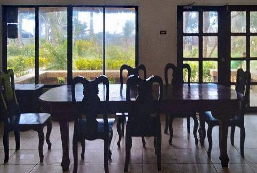 a dining room with a table and chairs and windows at Langub Beach Resort Sipalay by RedDoorz in Sipalay