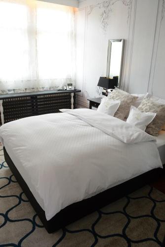 a large white bed in a bedroom with a window at Goldner Engel, Restaurant - Hotel - Metzgerei in Laudenbach